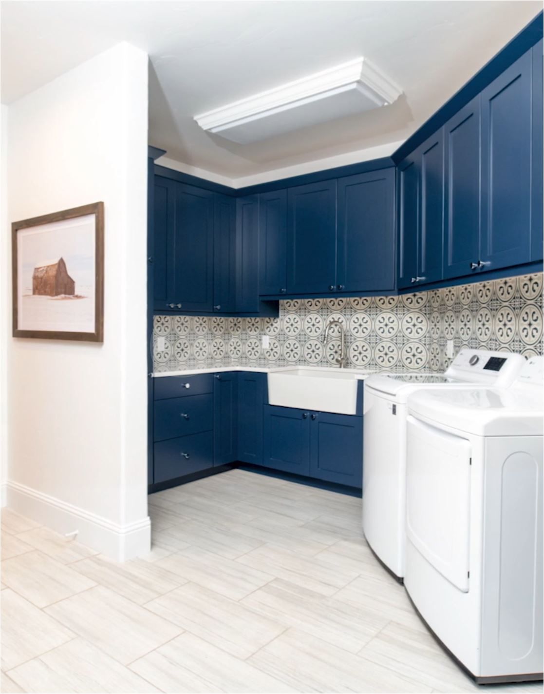 A laundry room with blue cabinets and white appliances