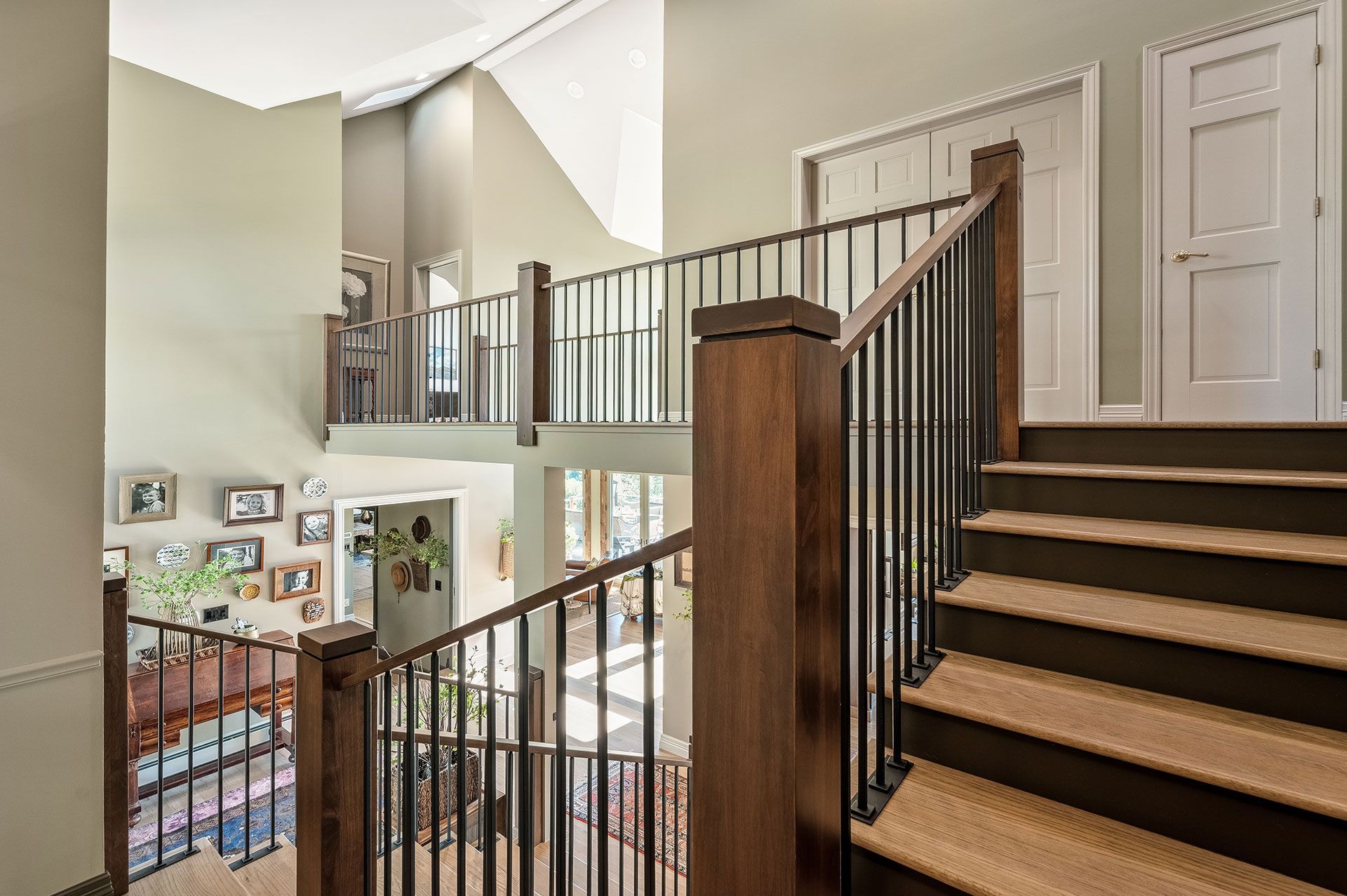 A wooden staircase with a metal railing in a house.