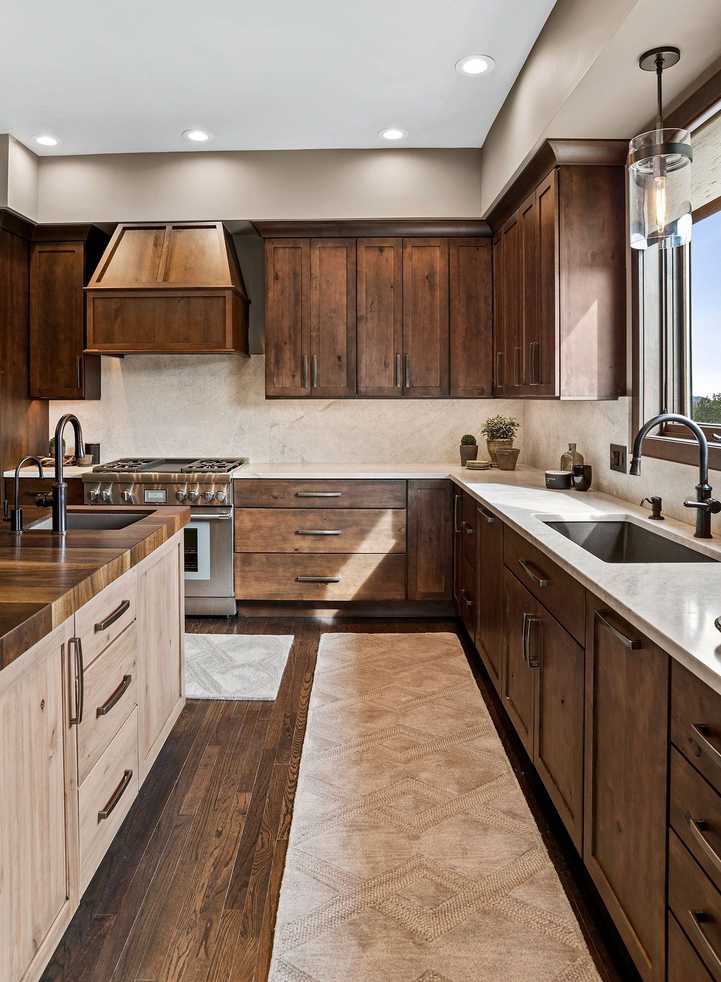 A kitchen with wooden cabinets , stainless steel appliances , a sink and a stove.