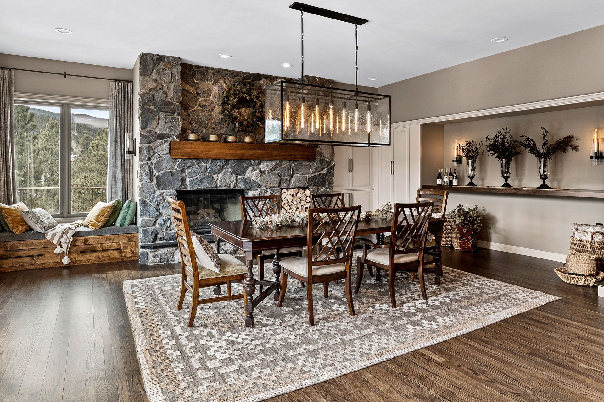 A dining room with a table and chairs and a fireplace.