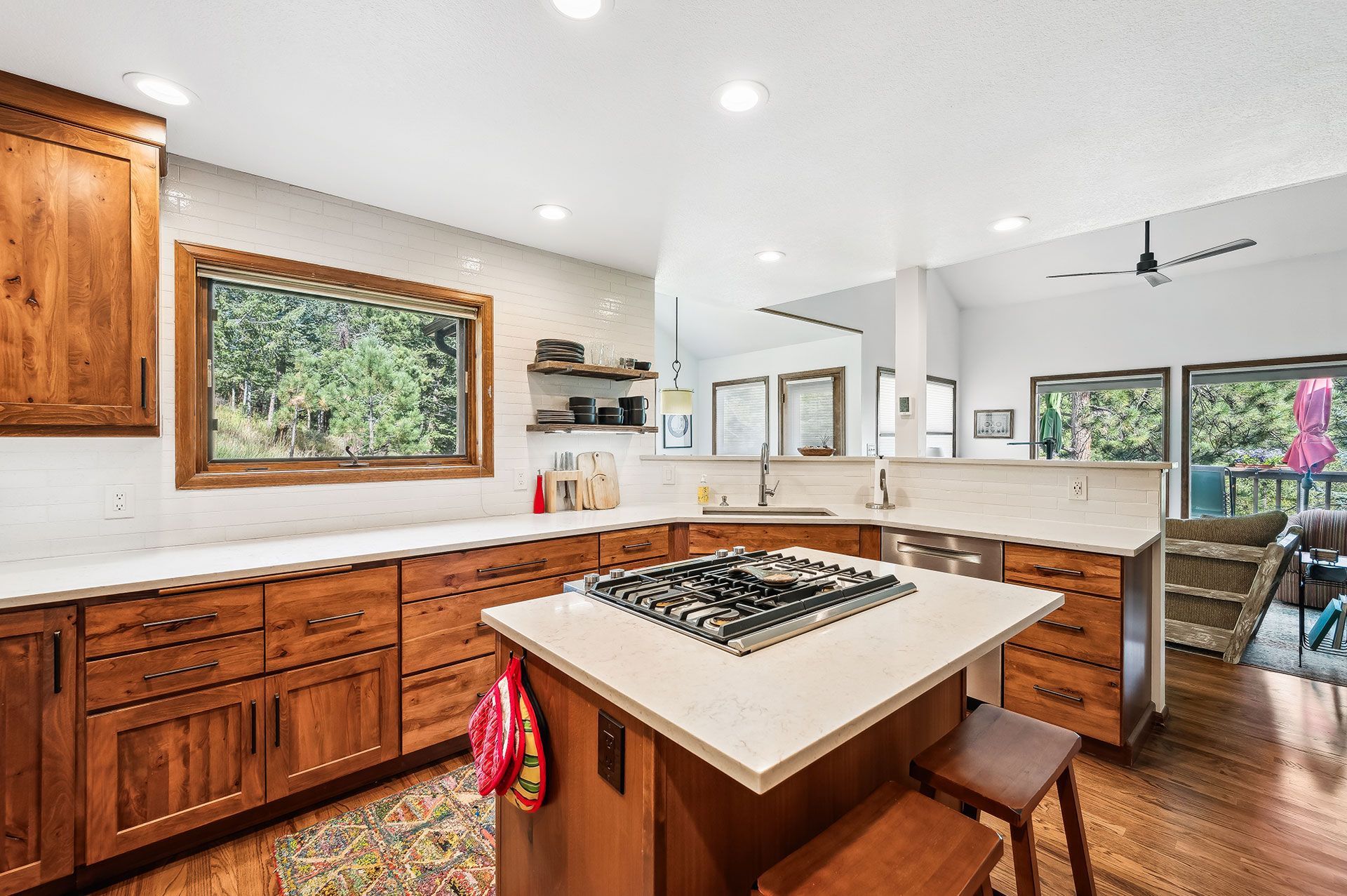 A kitchen with wooden cabinets and a large island with a stove top oven.