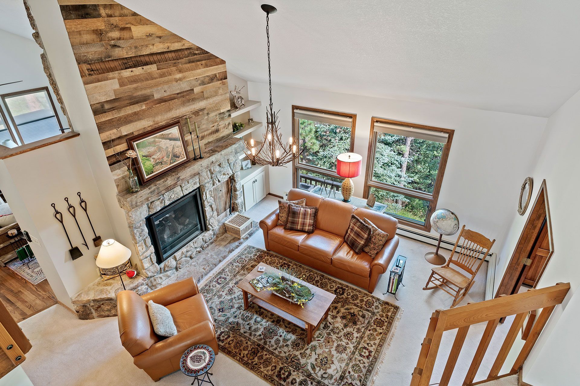 top view of a living room with a couch, chair, coffee table, and fireplace.
