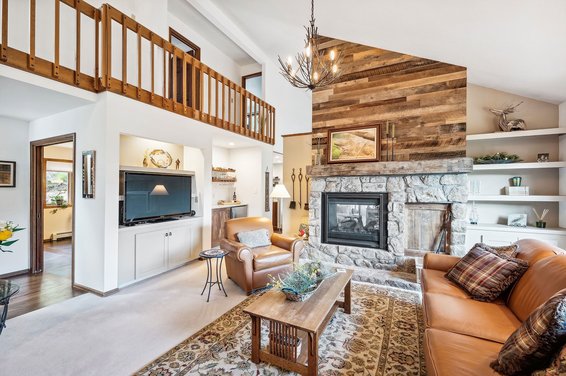 Living room with a couch, chair, coffee table and fireplace.