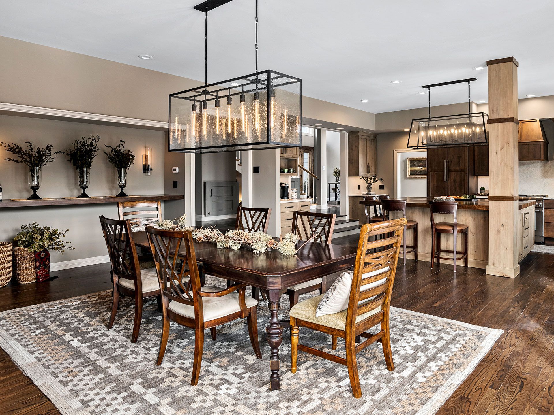 A dining room with a table and chairs and a rug.