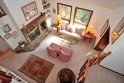 A top view of a living room with a fireplace and stairs.