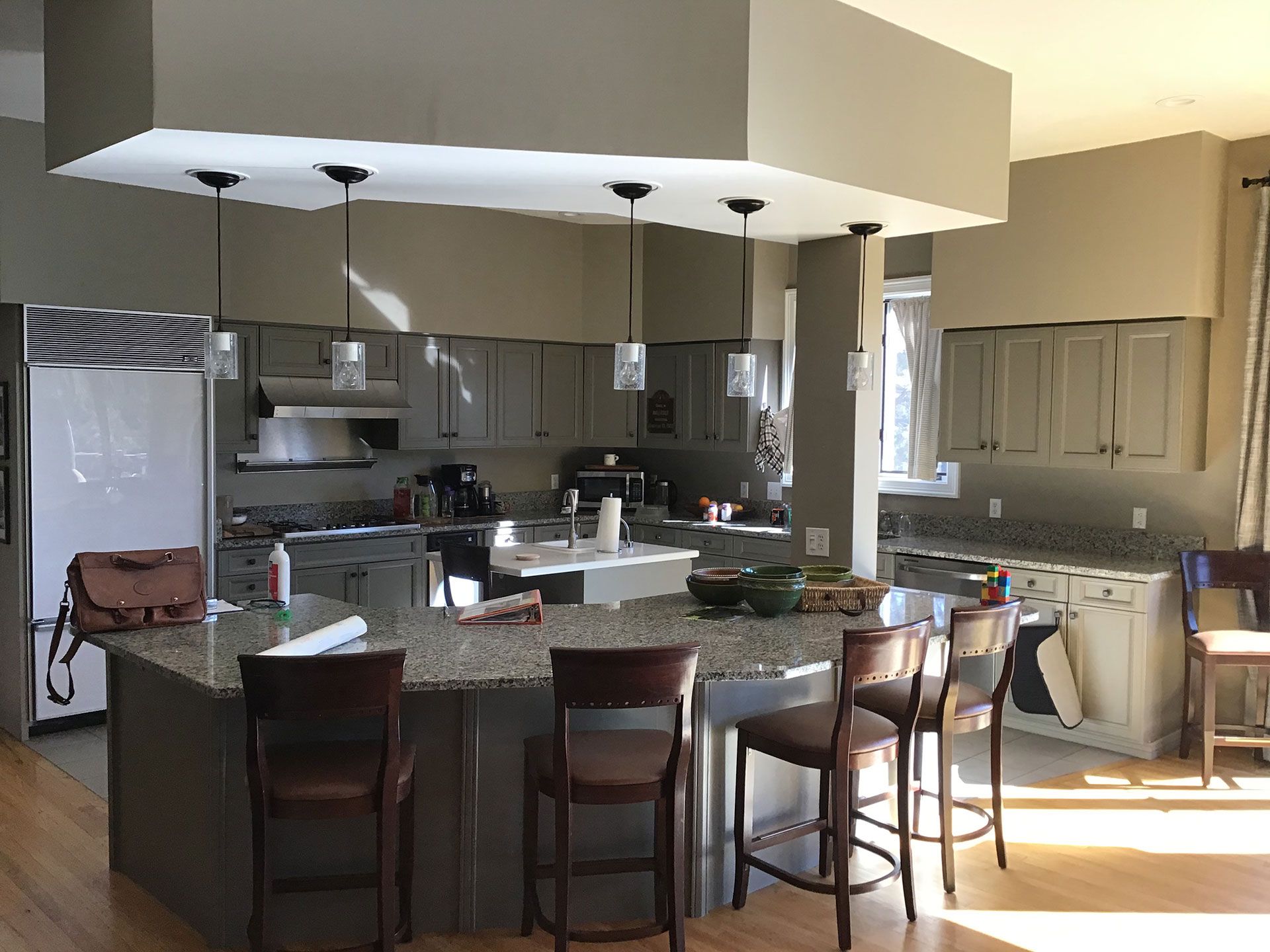 A kitchen with a large island and chairs in it