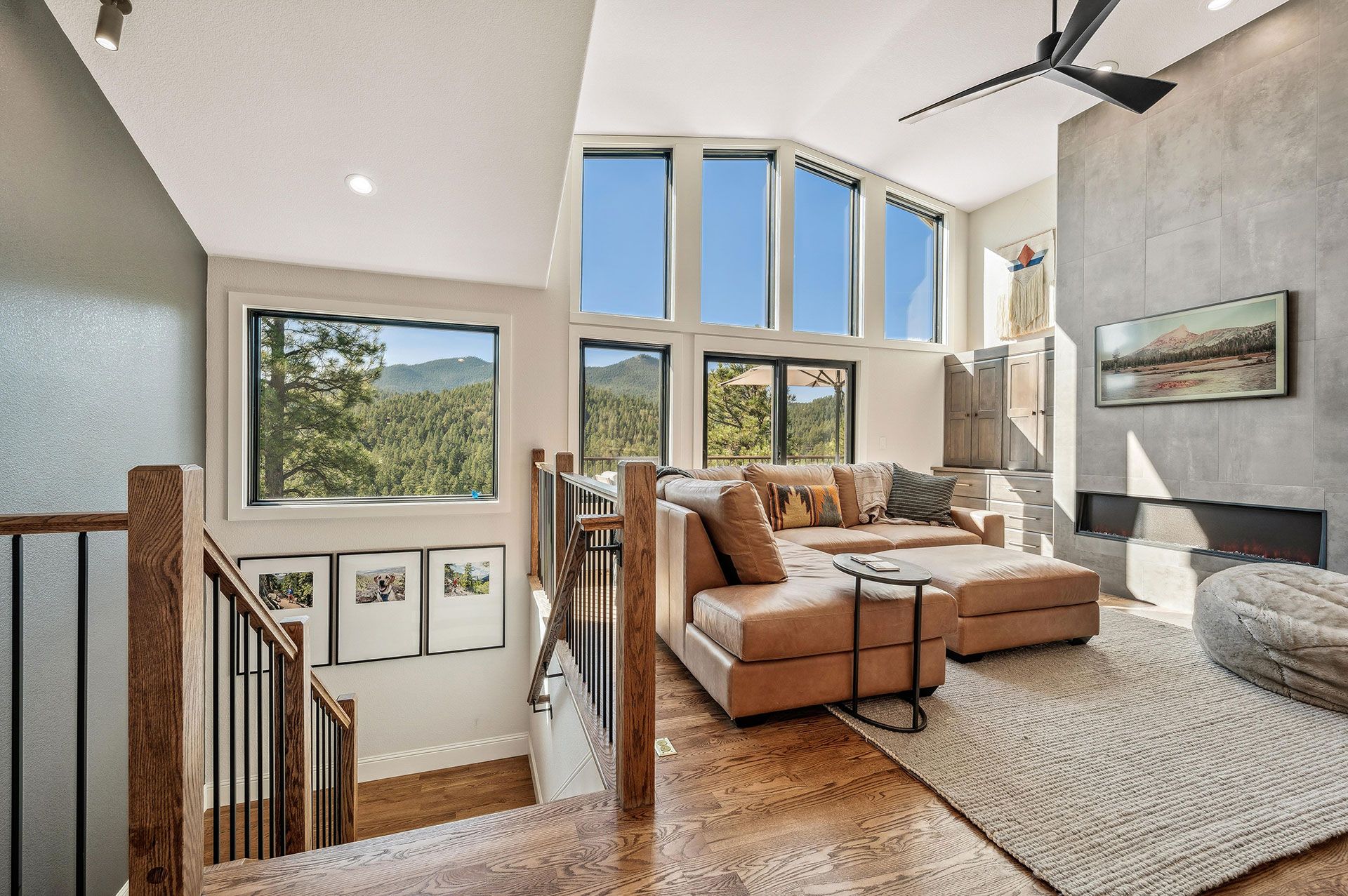 A living room with a lot of windows and a ceiling fan