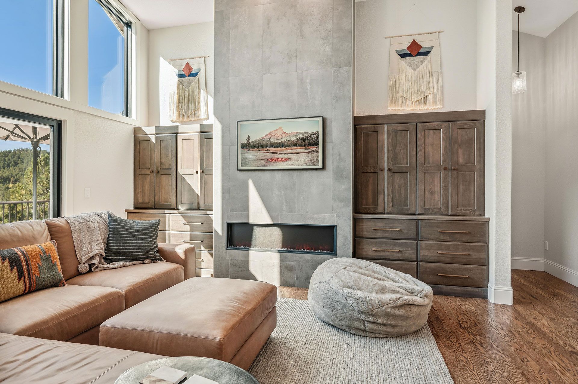 A living room with a couch , ottoman , fireplace and television.