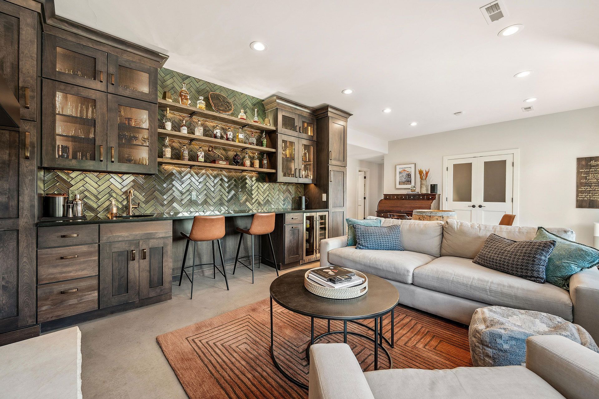 A living room with a couch , chairs , a table and a bar.