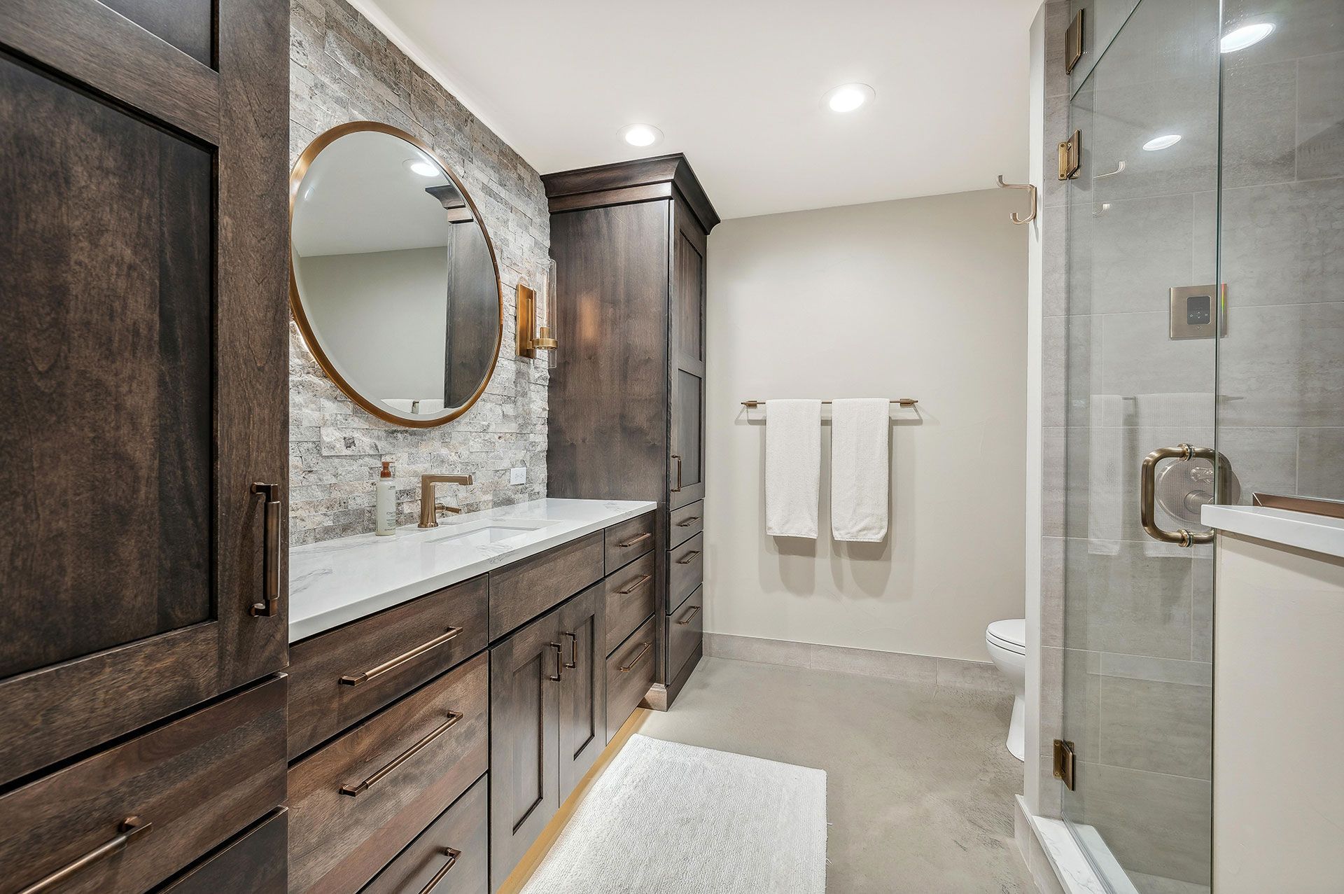 A bathroom with a sink , mirror , toilet and shower.