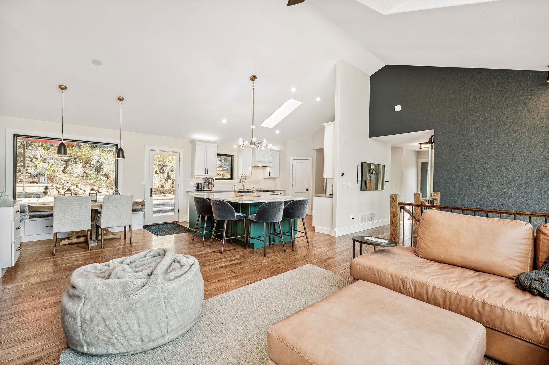 A living room with a couch , ottoman , table and chairs.