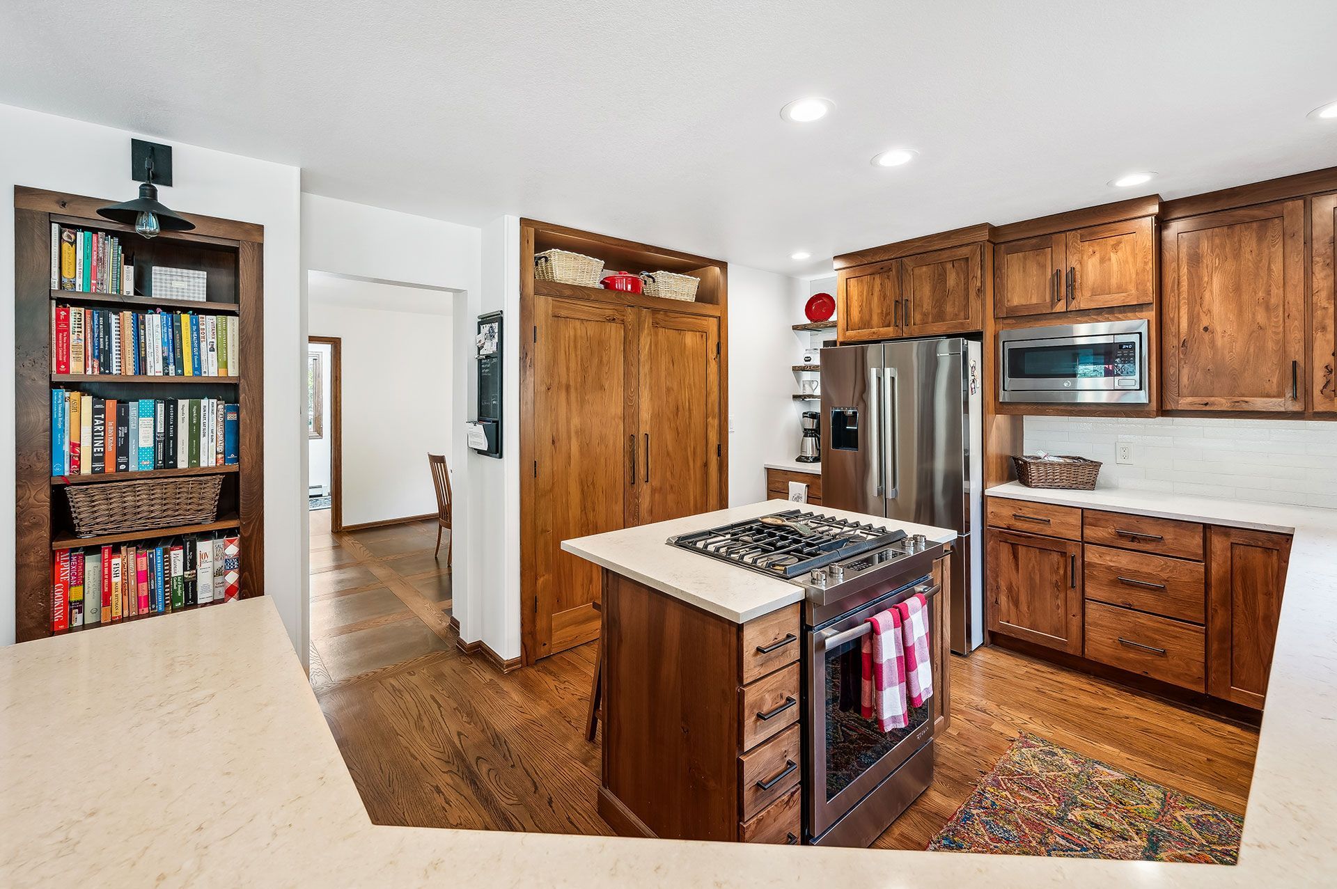 A kitchen with wooden cabinets , stainless steel appliances , and a large island.