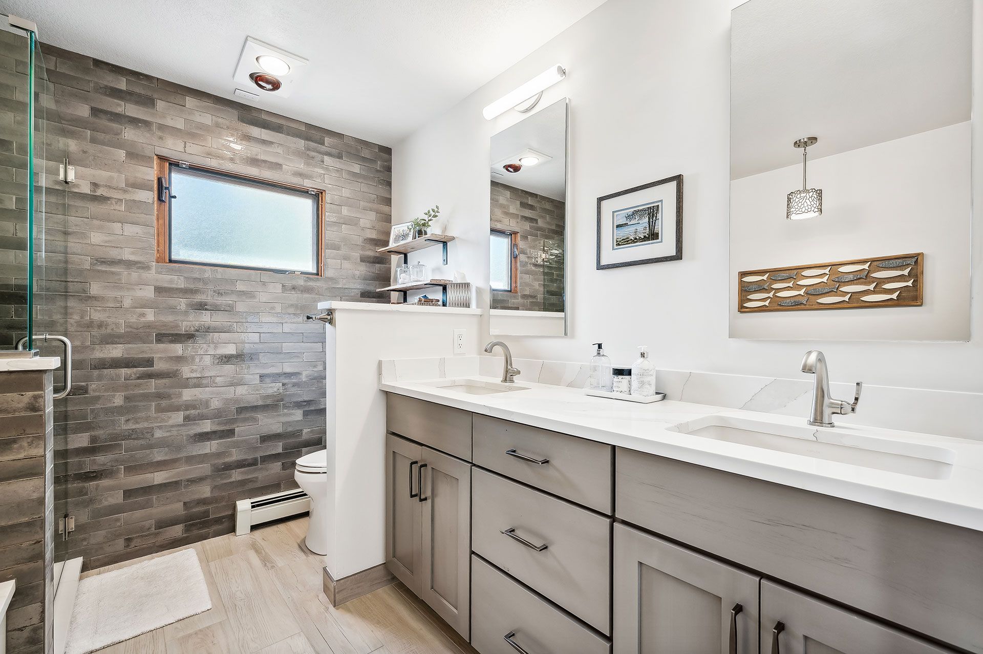 A bathroom with two sinks , a toilet and a shower.