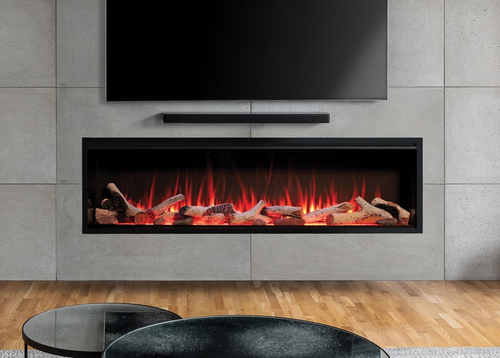 Electric fireplace with faux flames beneath a mounted TV and soundbar, against a concrete wall.