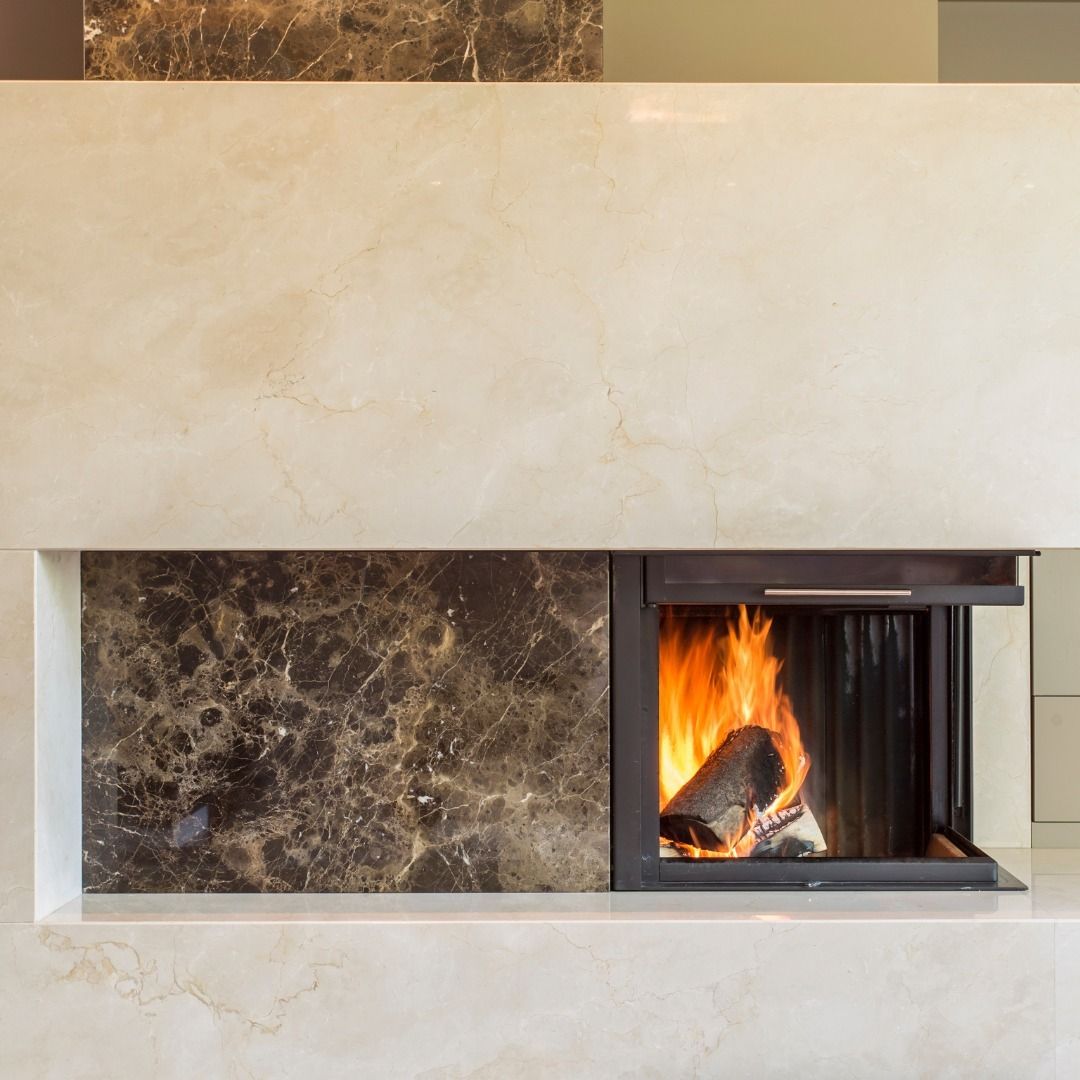 Fireplace with flames and burning log, surrounded by marble stone.
