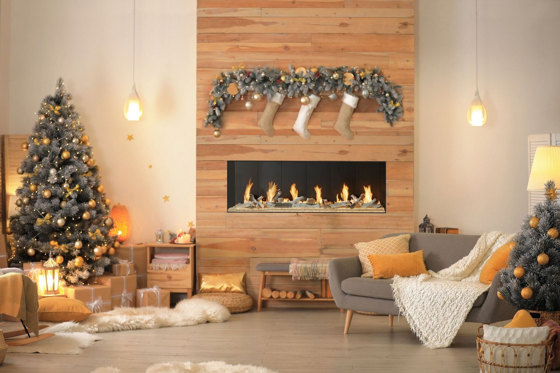 Cozy living room decorated for Christmas with a lit fireplace, decorated tree, and stockings.