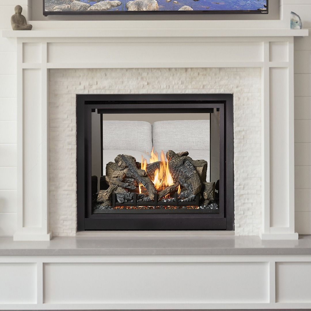 Fireplace with white mantel and stone surround. A gas fire burns inside the black framed hearth.