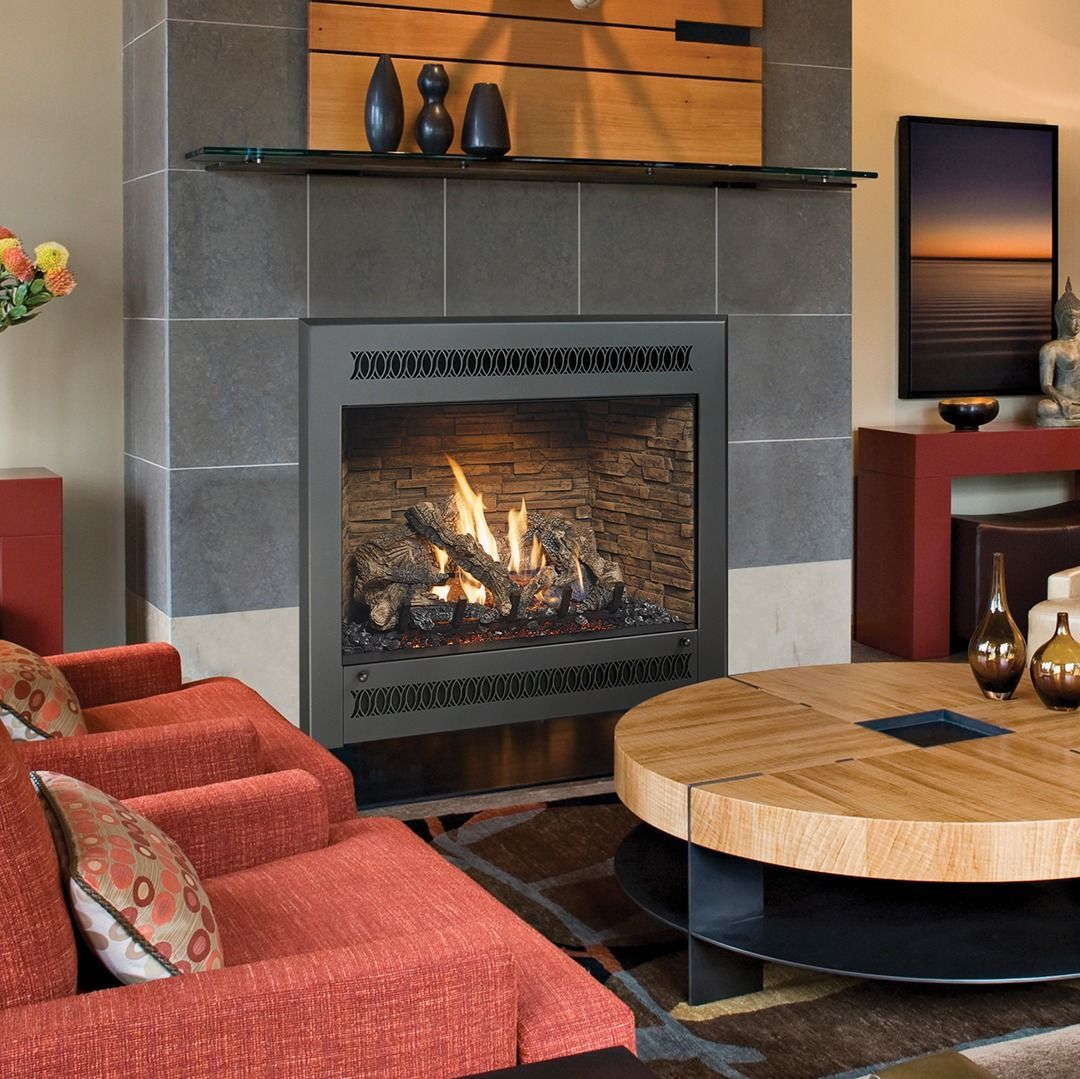 Cozy living room with fireplace and modern decor: orange sofa, wooden coffee table, and sunset art.