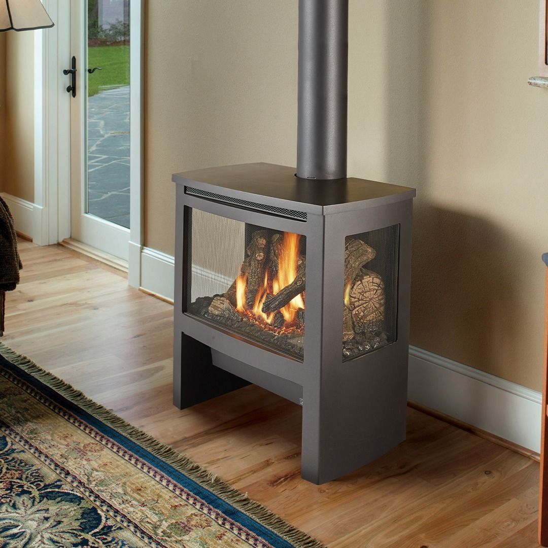Freestanding gas fireplace with visible flames and metal chimney in a room with hardwood floors.