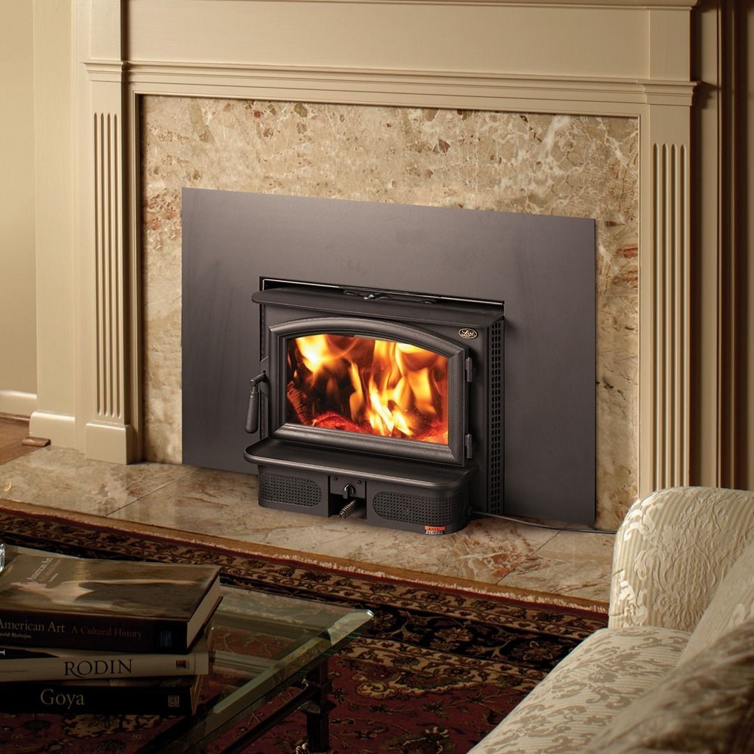 Fireplace insert with flames, set in a marble surround, with books and chair visible.