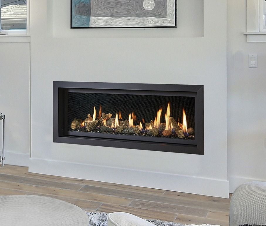 Modern fireplace built into a white wall, with flames and decorative rocks visible behind black mesh.
