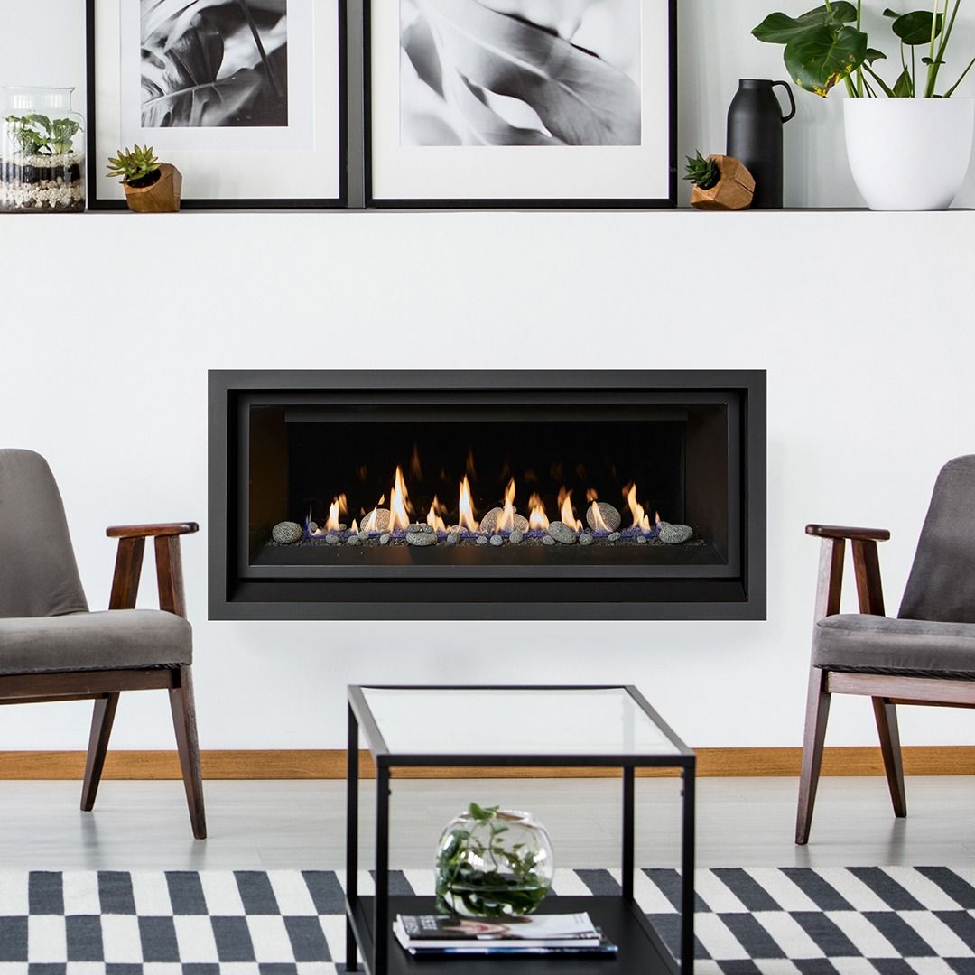 Modern living room with a lit fireplace, framed art, and seating.