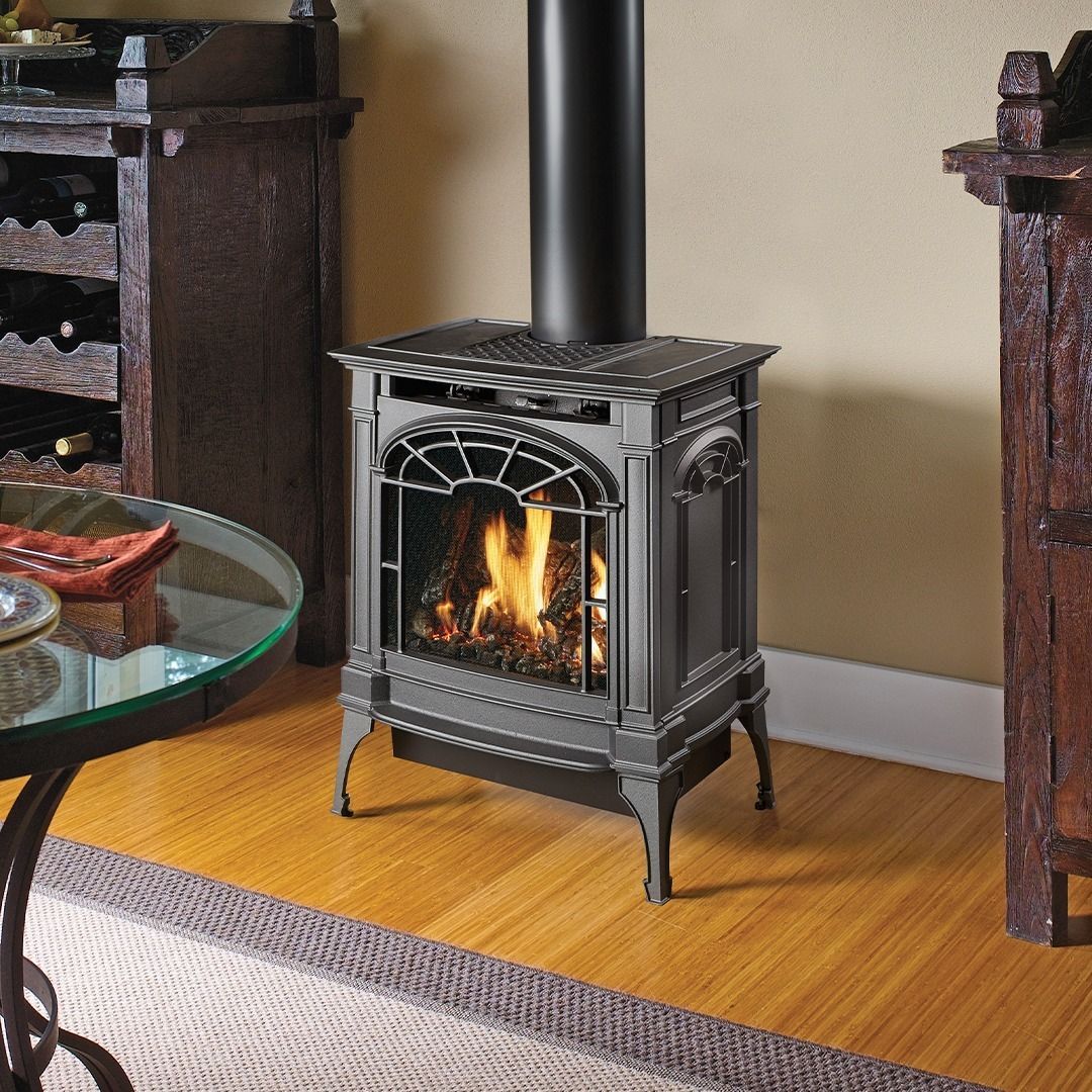 Gas stove with flames in a room with wood floors.