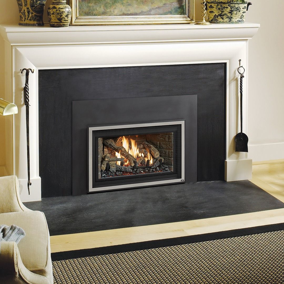 Fireplace with flames and decorative tools on a slate hearth, framed by a white mantel.