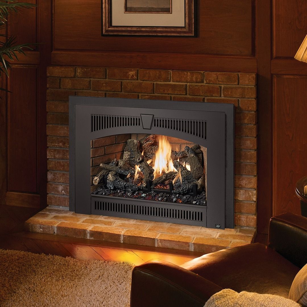 Gas fireplace with black frame and burning flames in brick hearth.