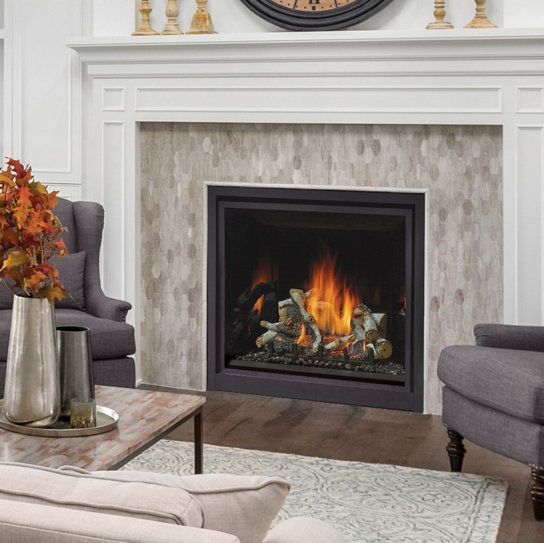 Fireplace with flames, decorated mantel, flanked by armchairs in a living room setting.