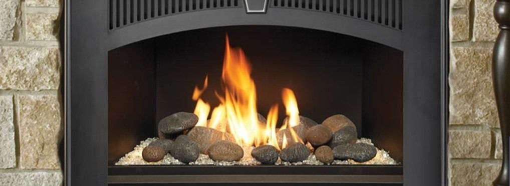 Fireplace with flames and rocks, set in a stone and dark metal frame.