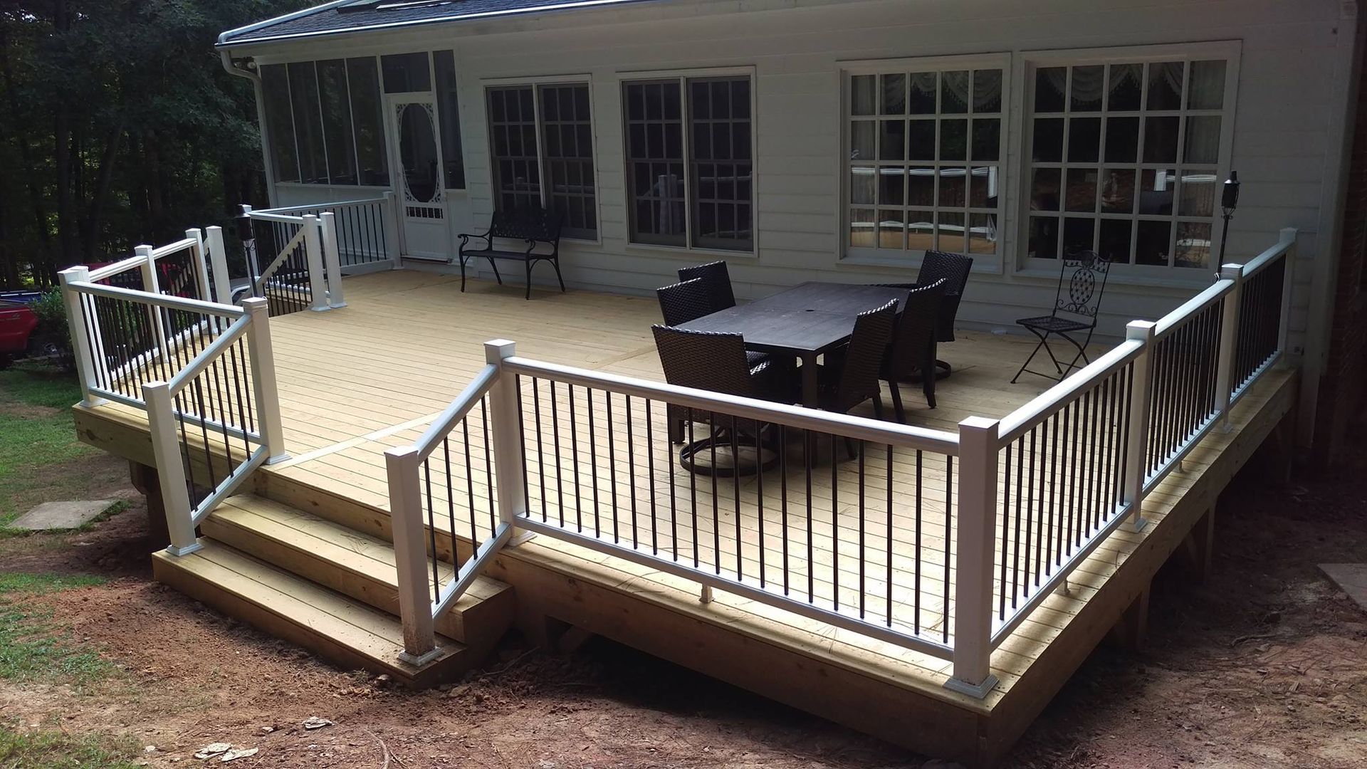 A wooden deck with a table and chairs on it
