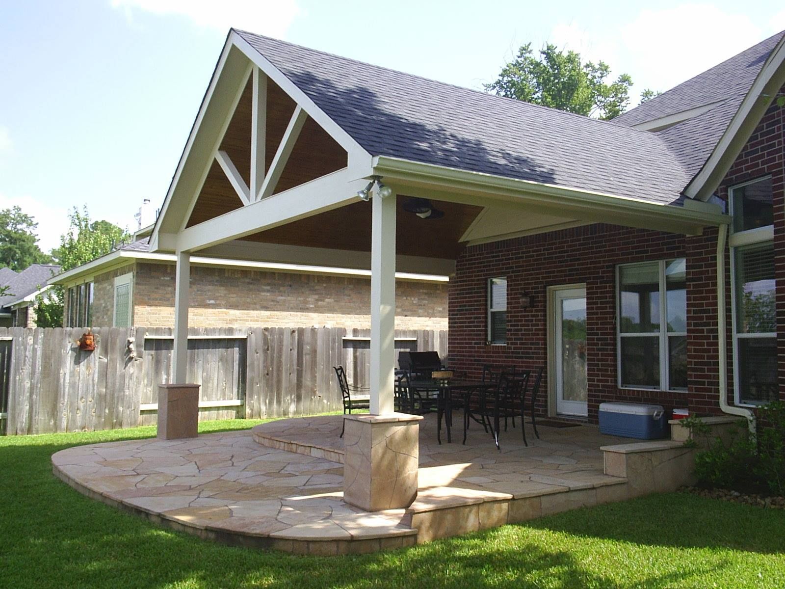 A brick house with a covered patio in front of it