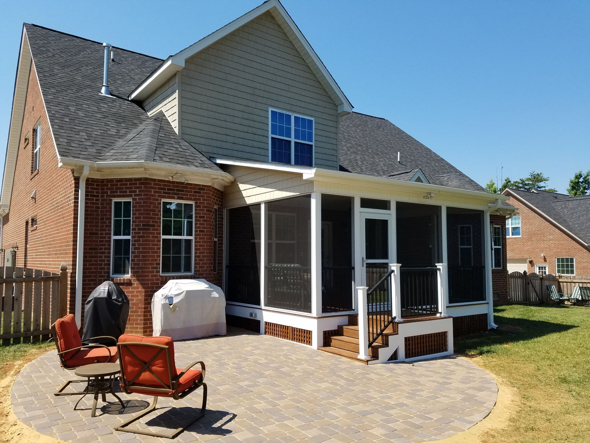 A house with a screened in porch and patio area