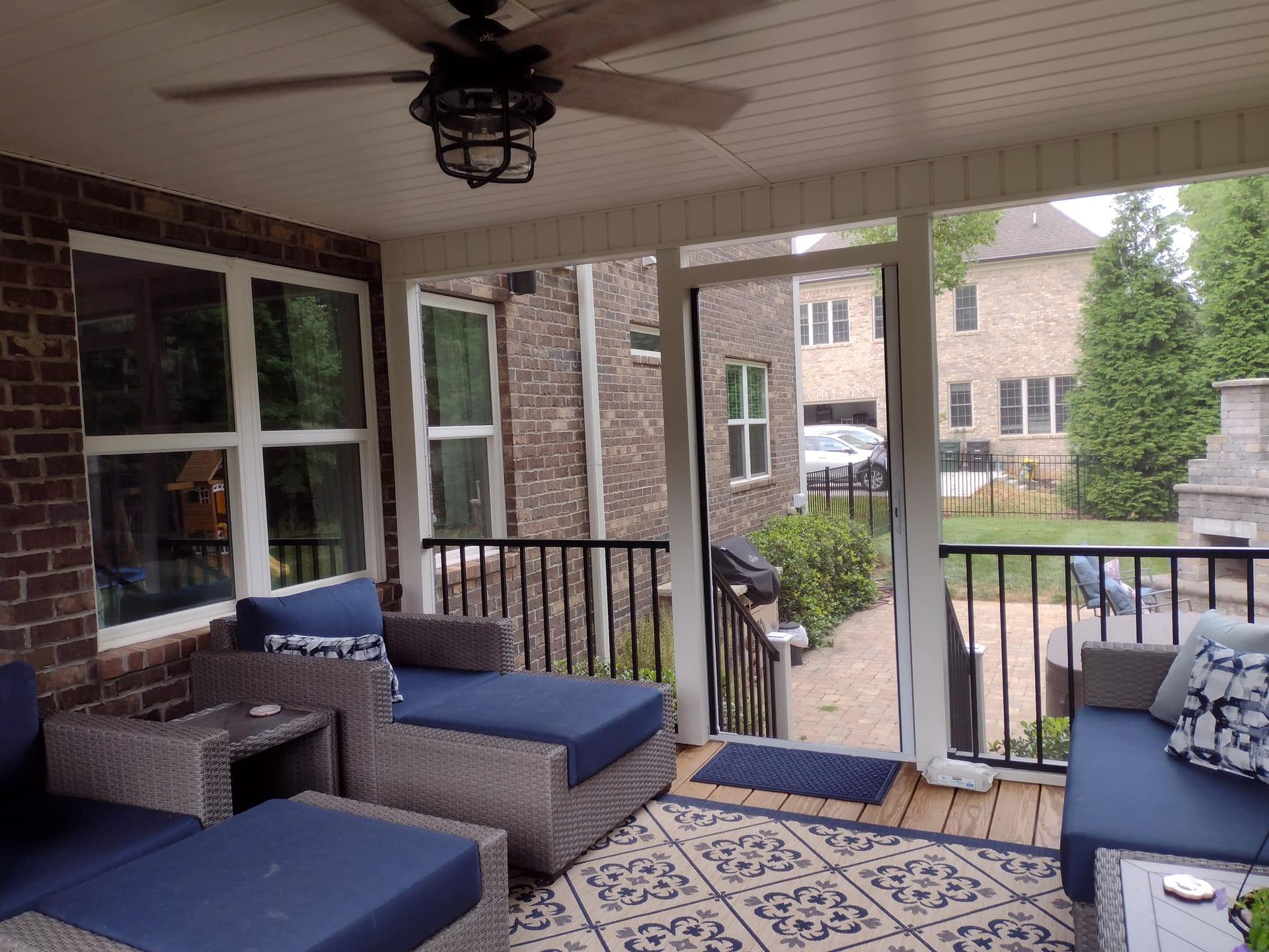 A screened in porch with furniture and a ceiling fan