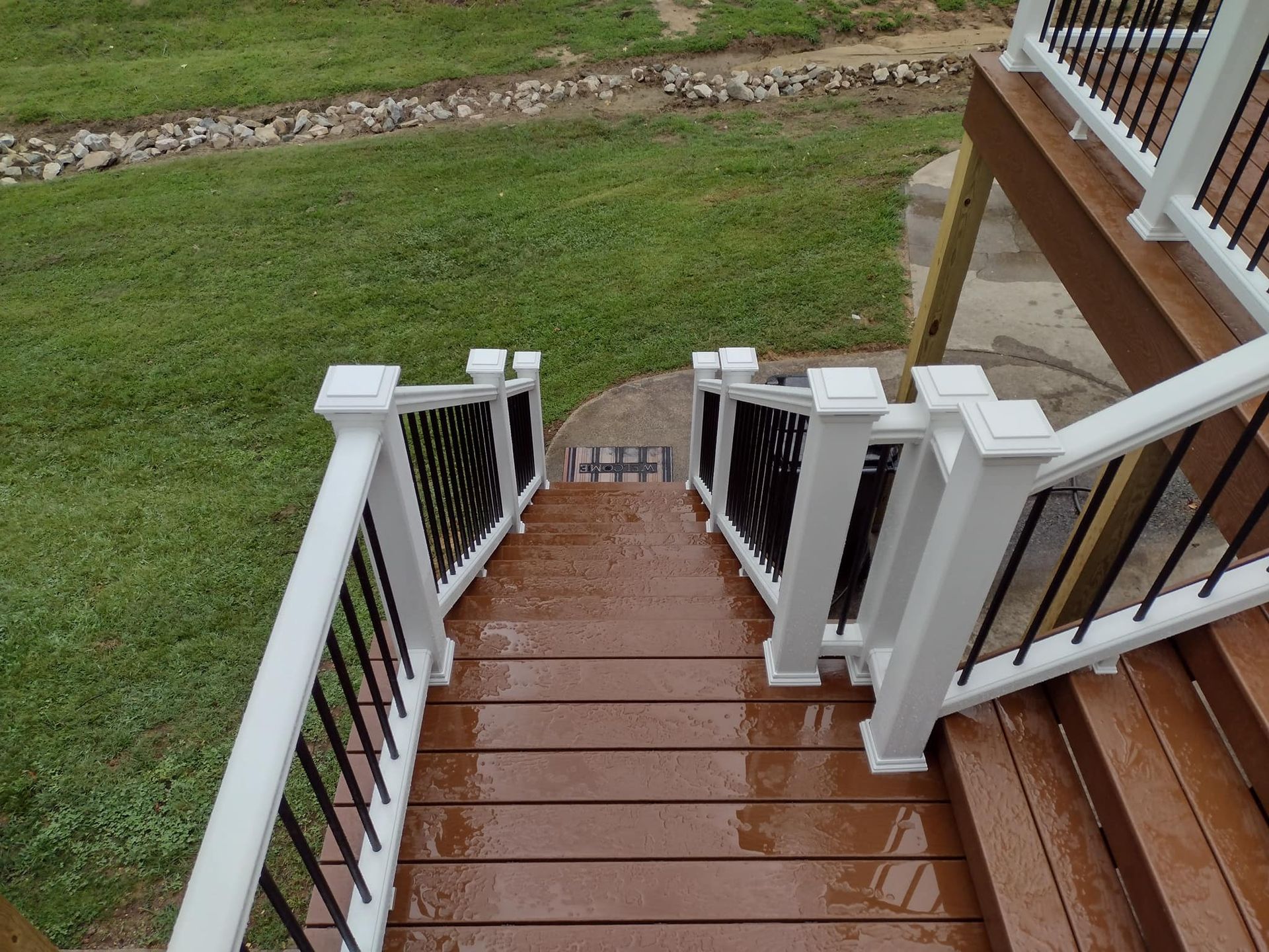 A set of stairs leading up to a deck with a white railing.