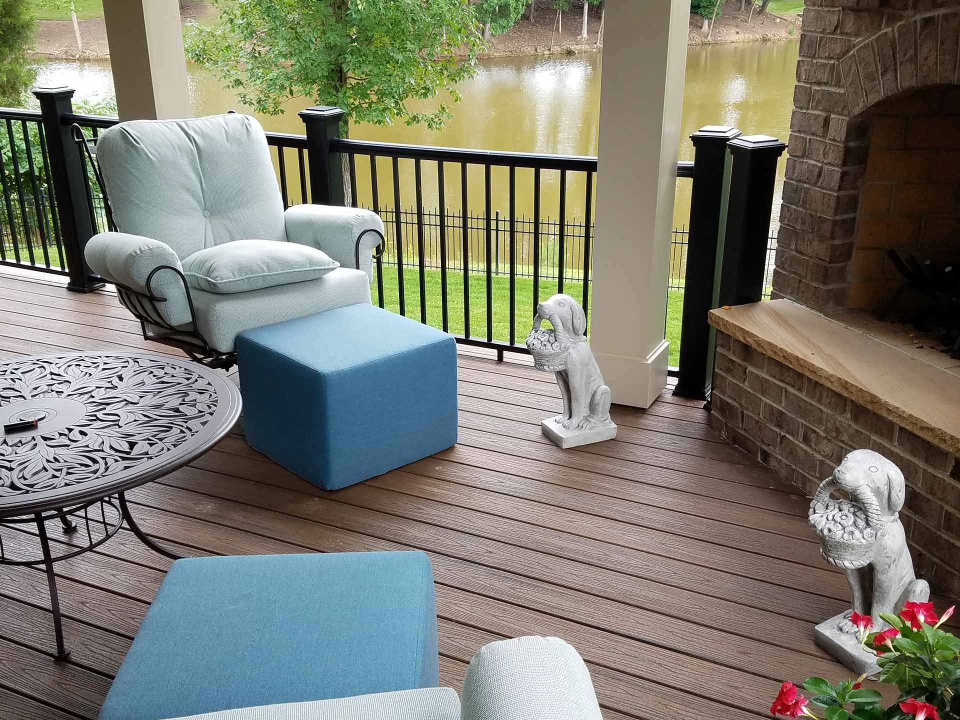 A deck with a chair and ottoman and a fireplace