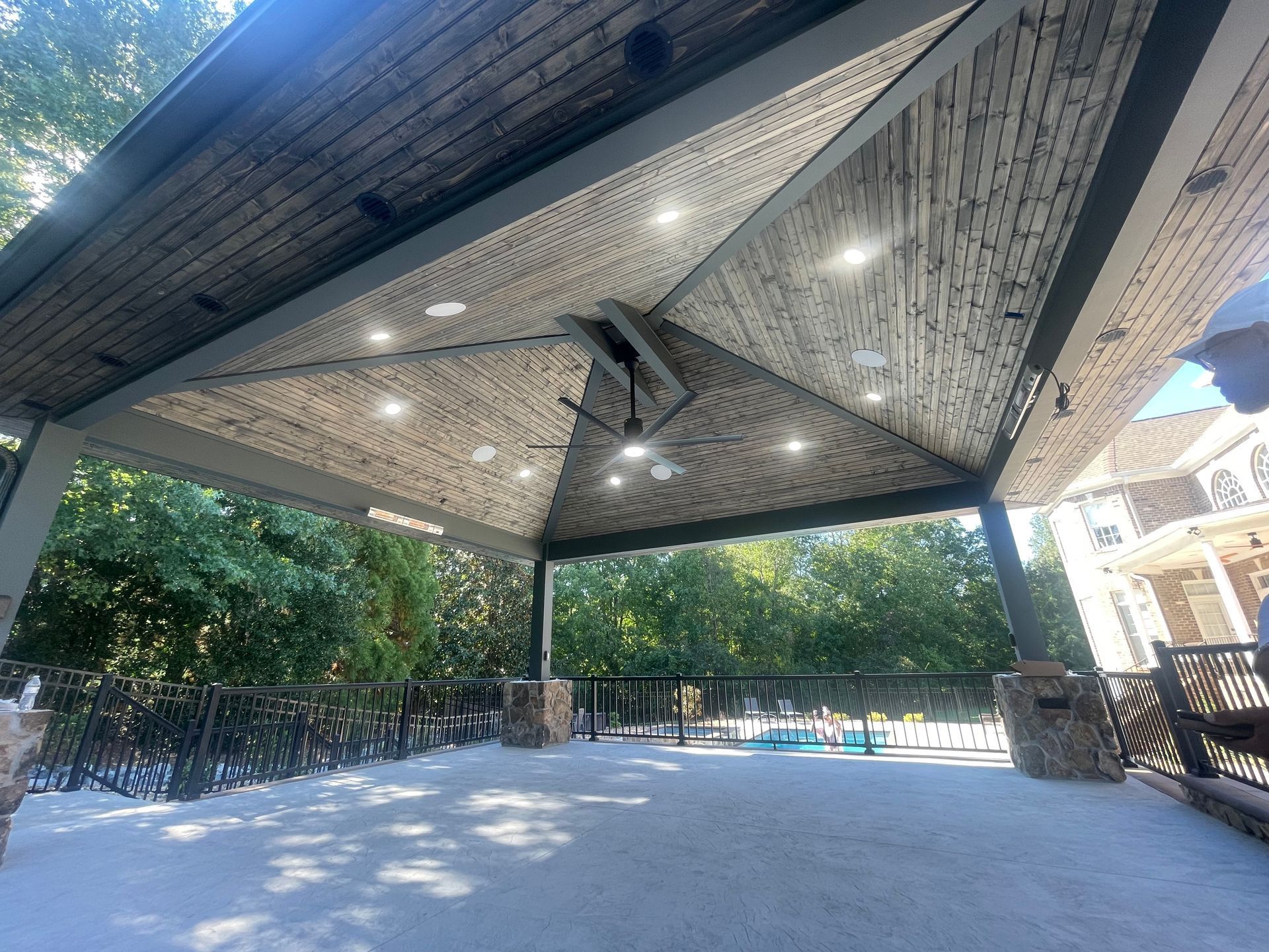 A gazebo with a table and chairs in the middle of a forest.