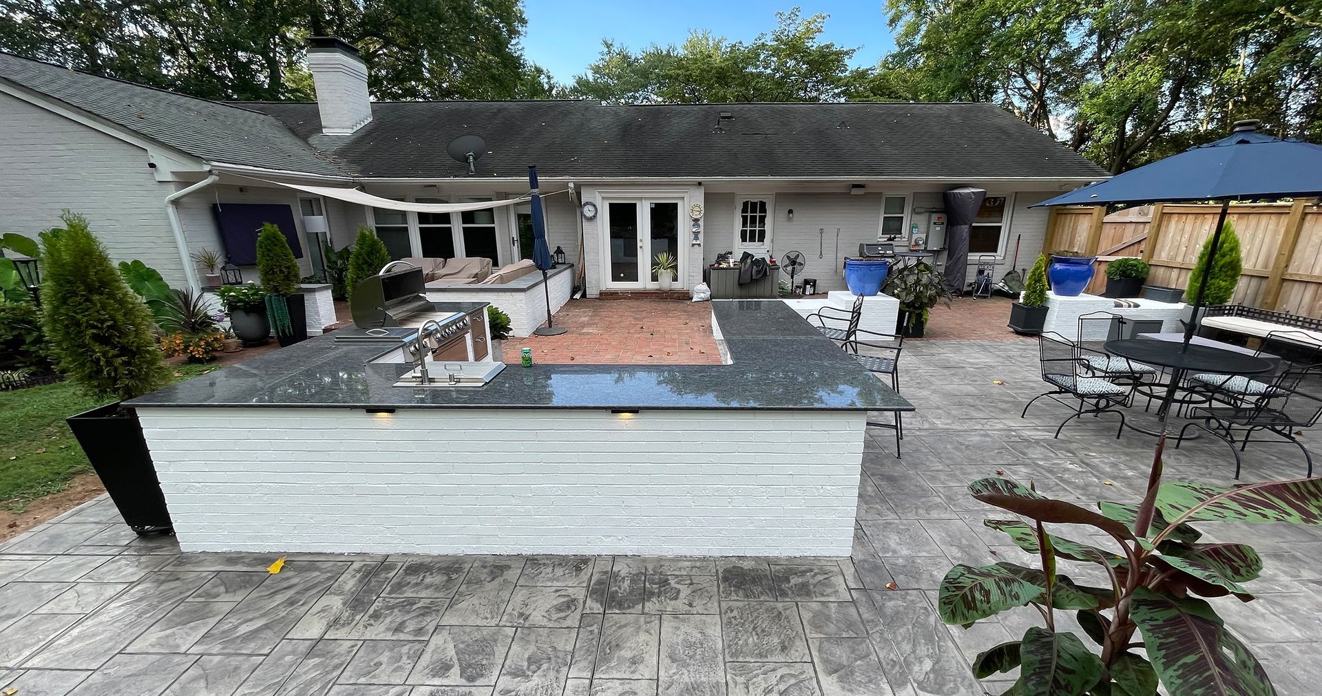 The backyard of a house with a large kitchen and patio area.