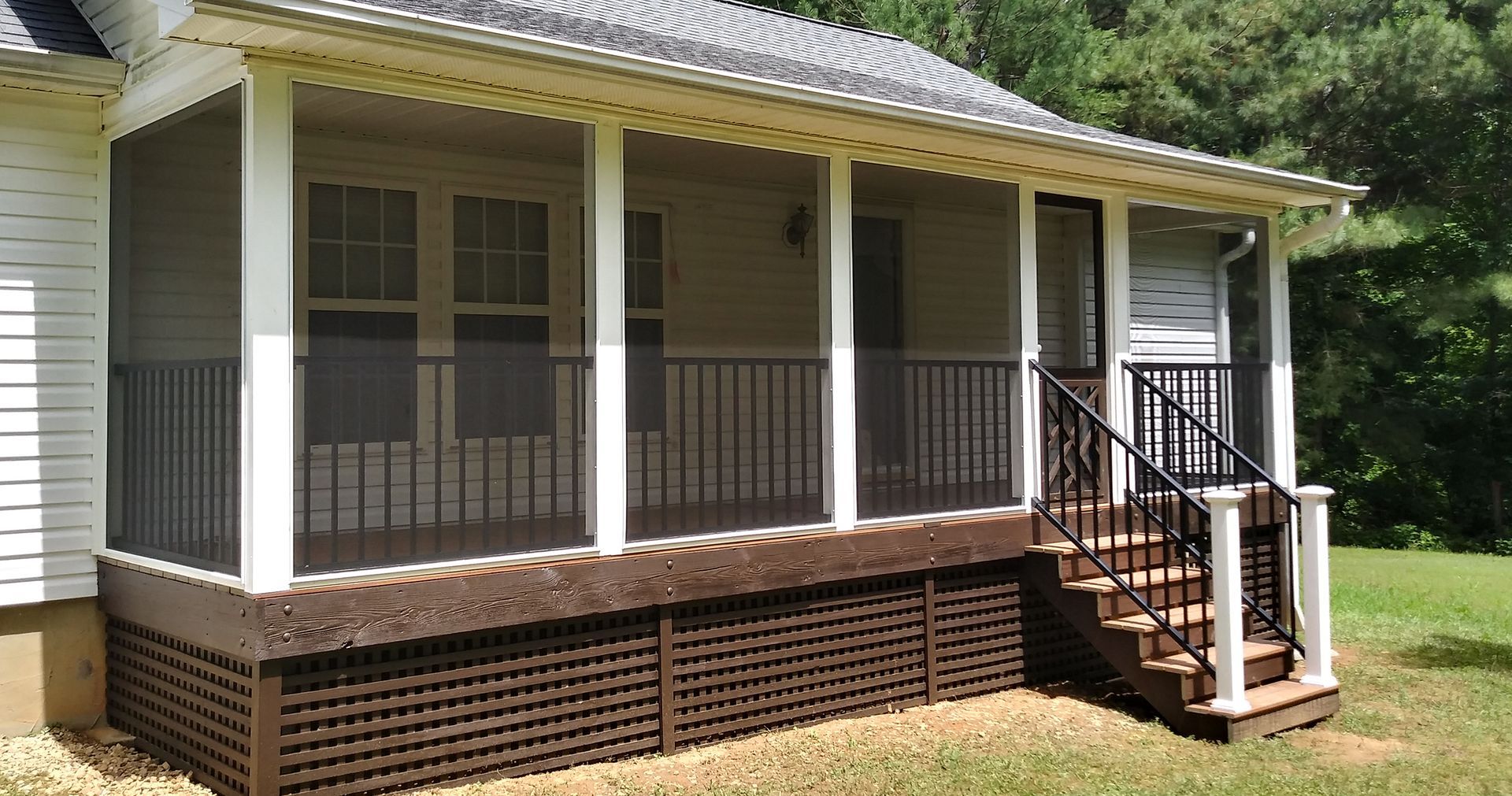A screened in porch with stairs on the side of a house.