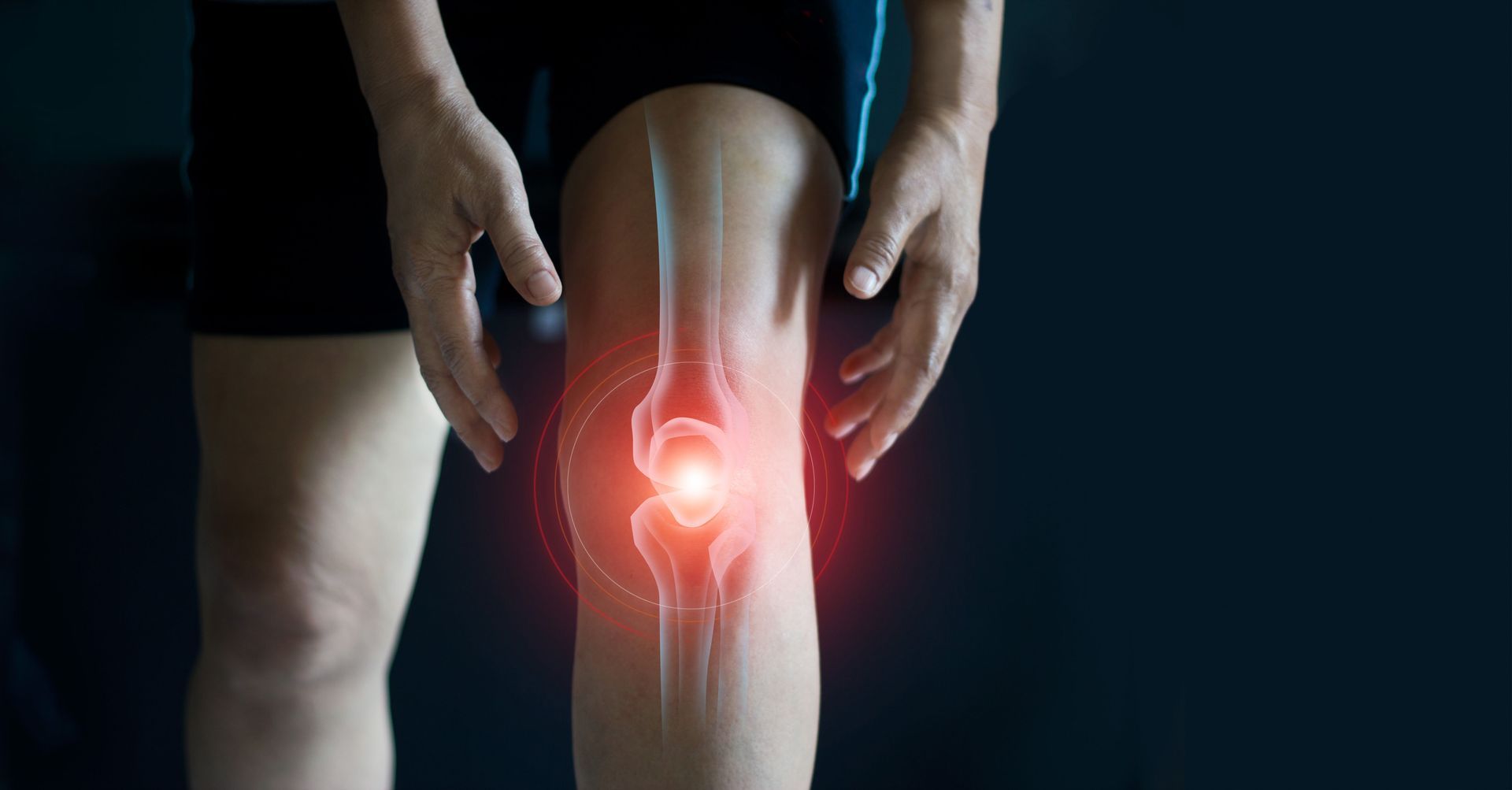 A person is holding their knee in pain.