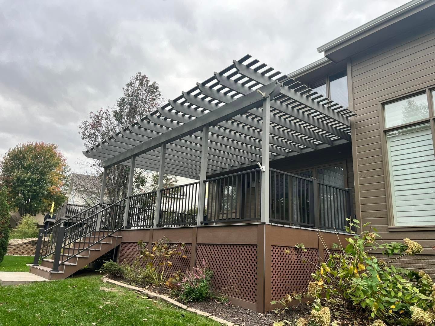 Back deck with pergola, stairs, and lattice skirting on a house exterior