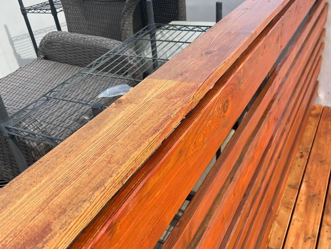 Weathered wooden bench on a patio with a metal chair in the background