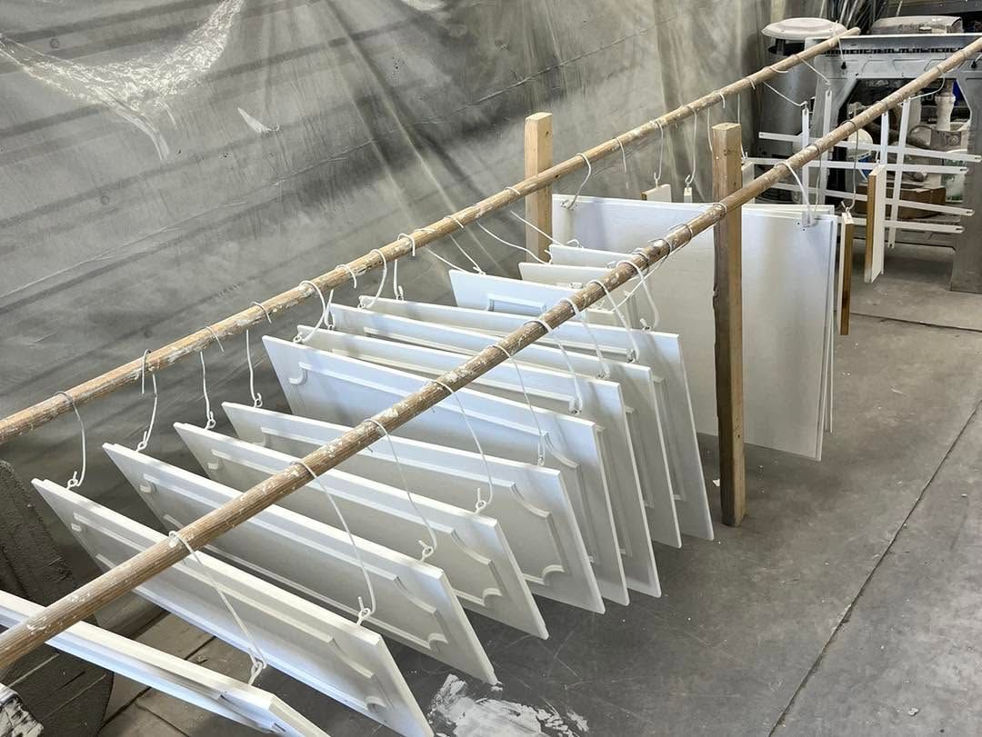 White panels drying on racks in an industrial workshop
