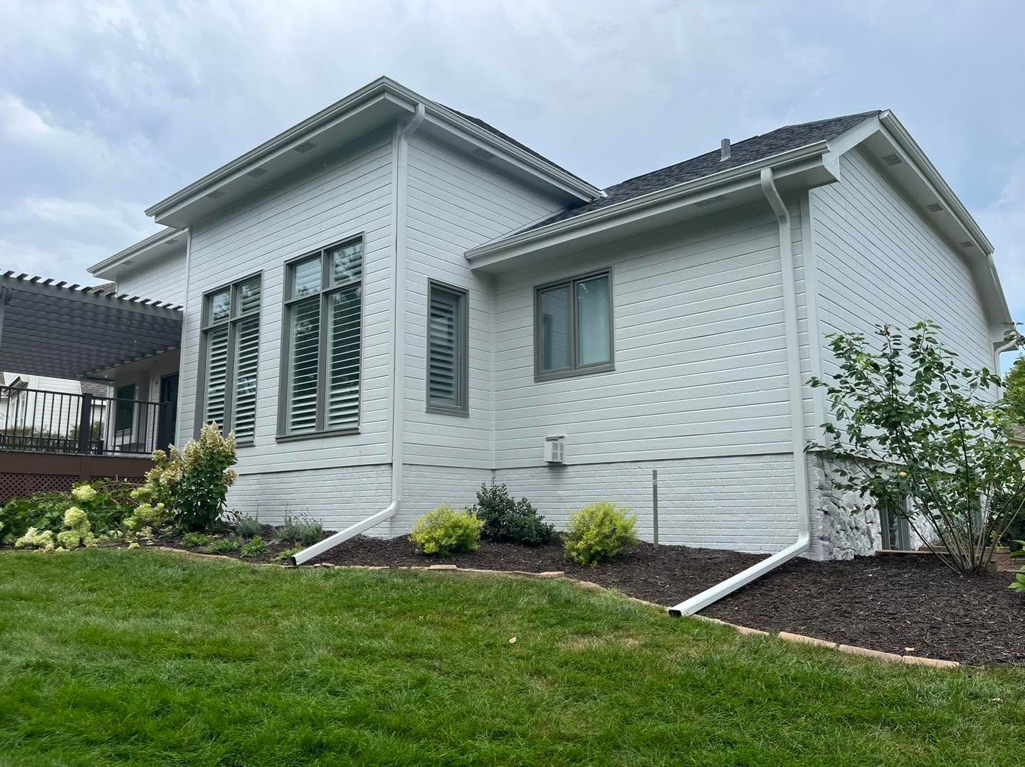 Modern single-story white house with green lawn and landscaped front yard