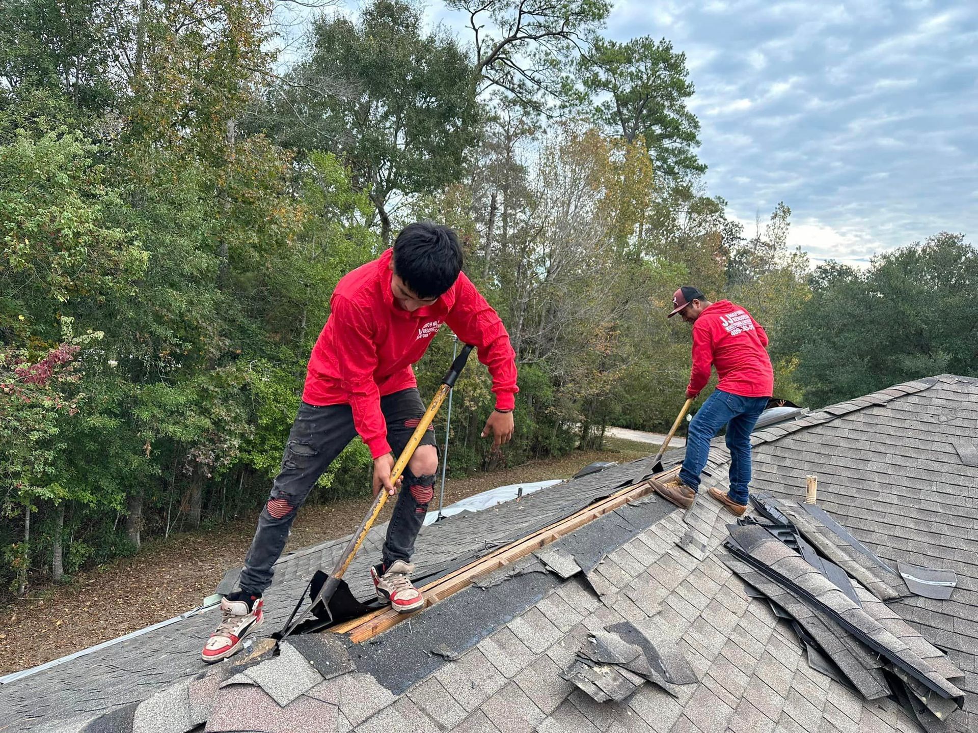 two men are working on the roof of a house .