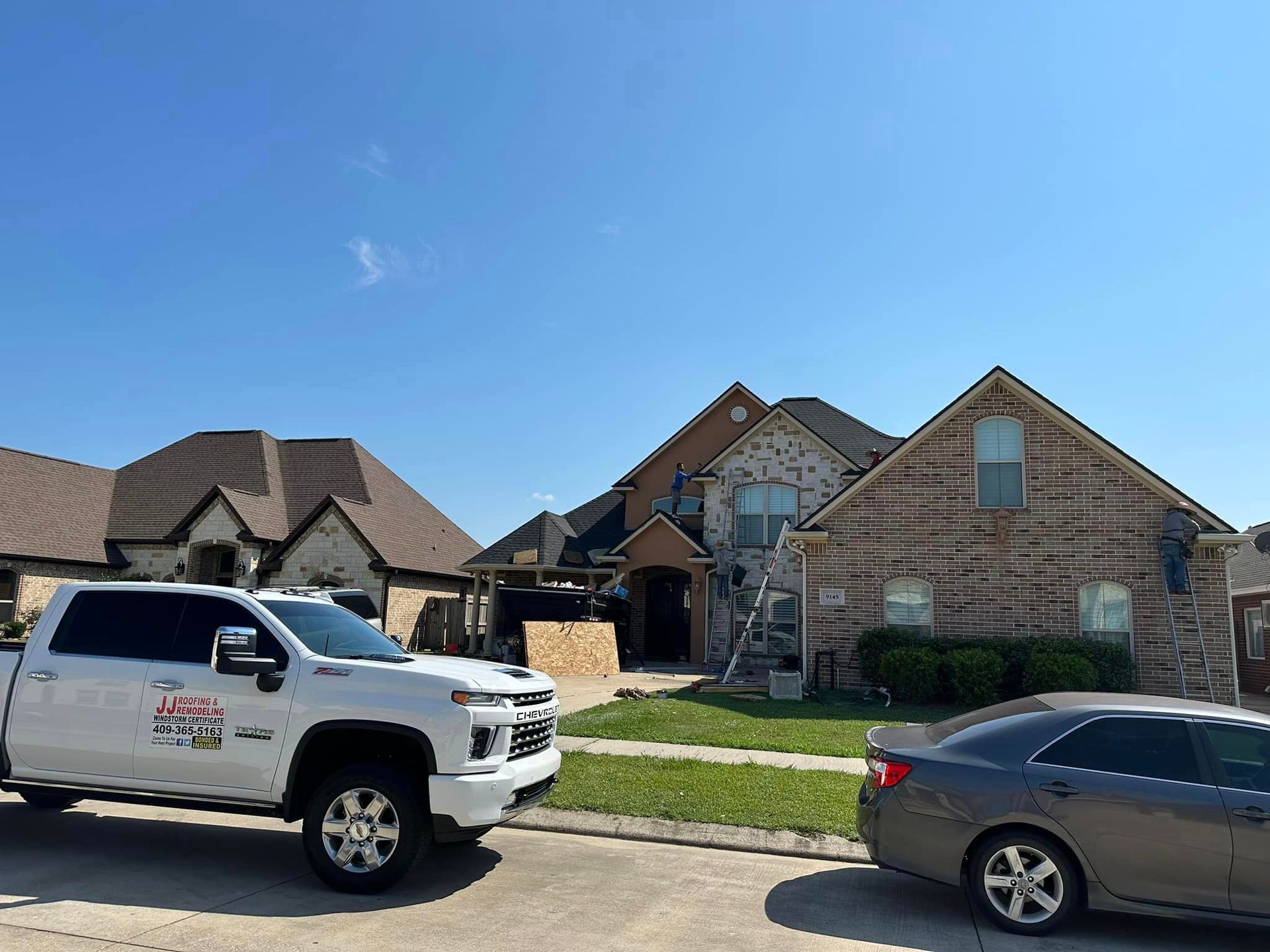 a truck and a car are parked in front of a house .