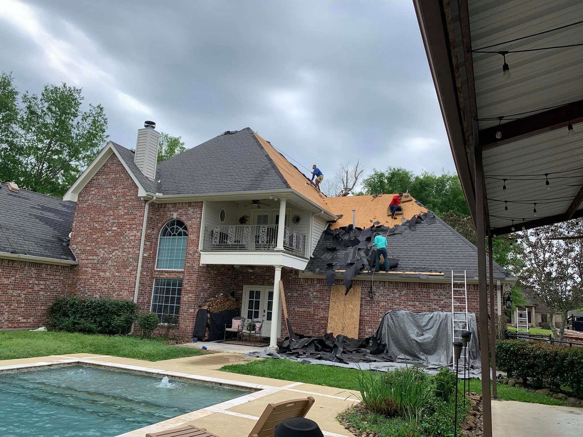 a large brick house with a pool in the backyard is being remodeled .