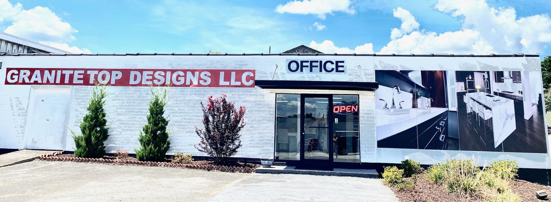 Exterior of Granite Top Designs LLC office building with a large photo of a countertop.