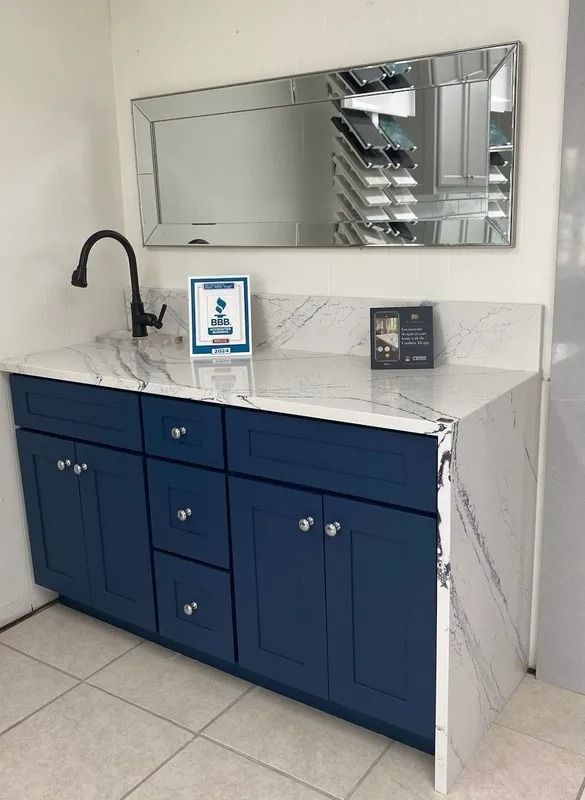 A bathroom vanity with blue cabinets and a large mirror